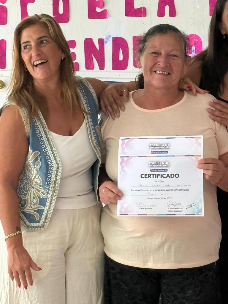 Una egresada recibe su certificado de la Escuela de Emprendedores junto a su capacitadora